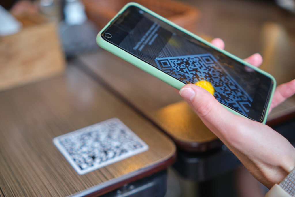 Customer using a mobile phone and QR code to order a meal