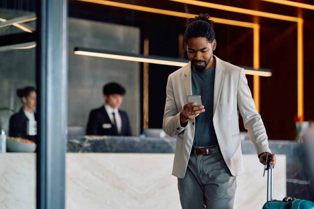 Hotel guest using his mobile phone to check in